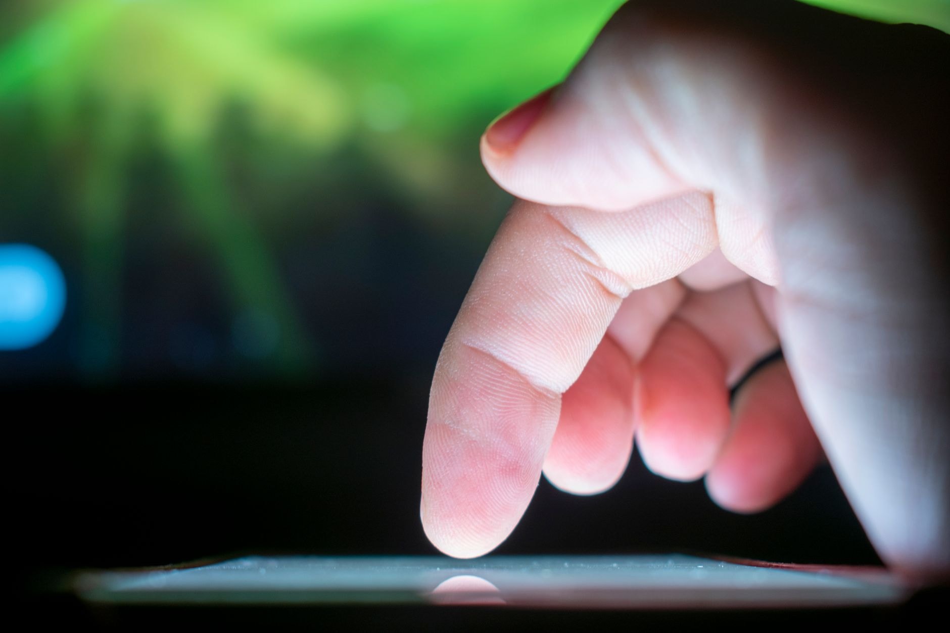 Pouce sur l'écran d'un smartphone prêt à toucher un lien