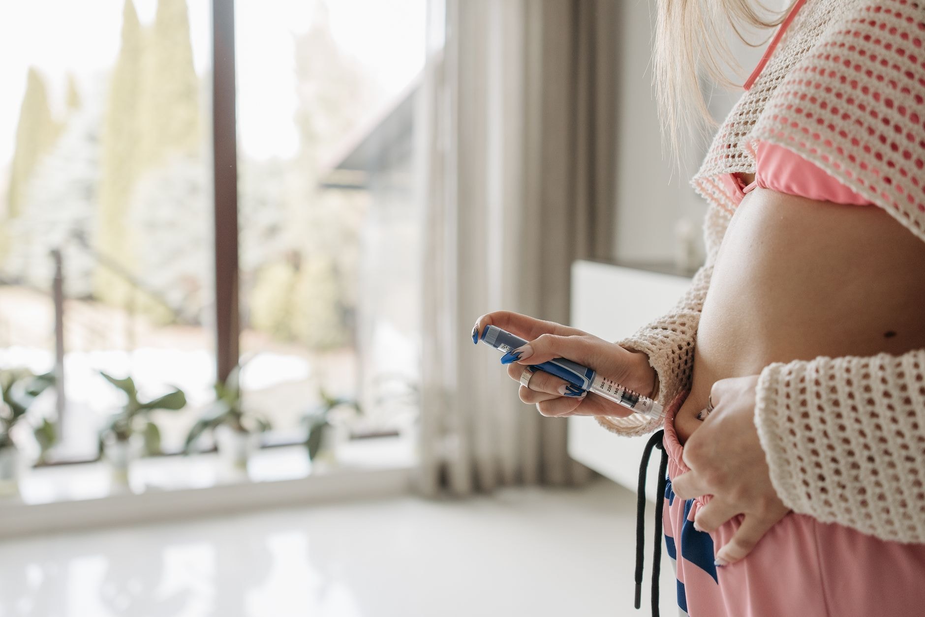 Femme tenant un stylo injecteur près de son ventre