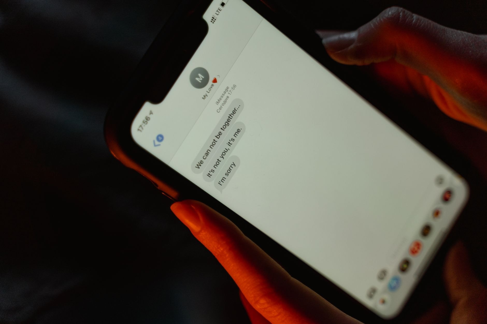 Personne lisant un SMS sur son téléphone le soir