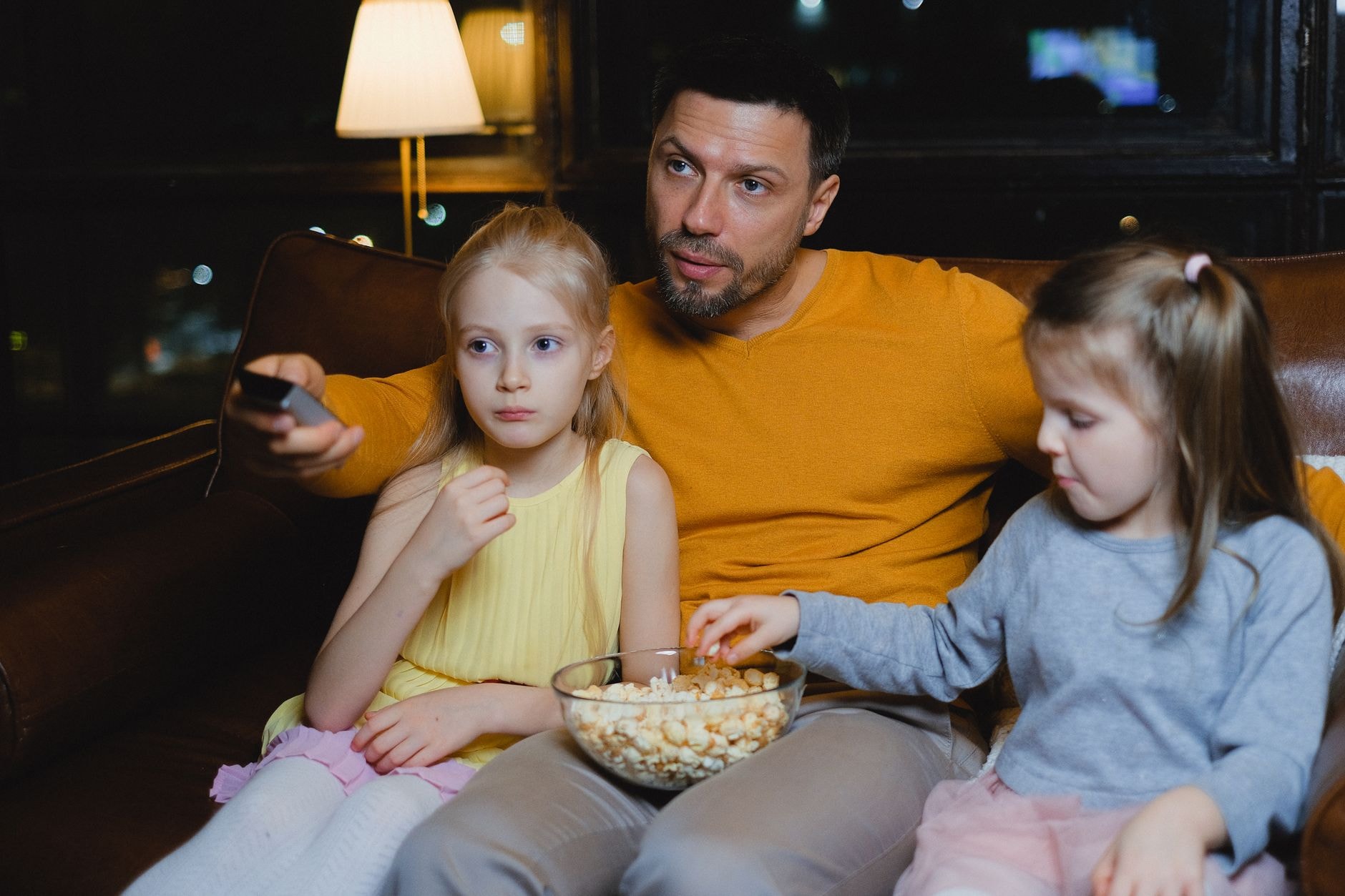 Famille regardant un film sur un grand téléviseur le soir