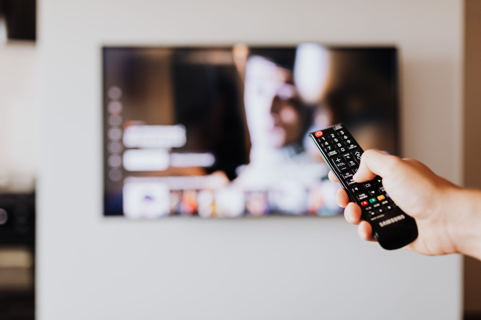 Télécommande pointée vers un téléviseur affichant une plateforme de streaming