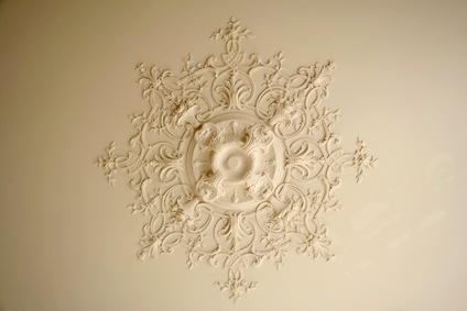 La pose d’une rosace au plafond, simplement décora
