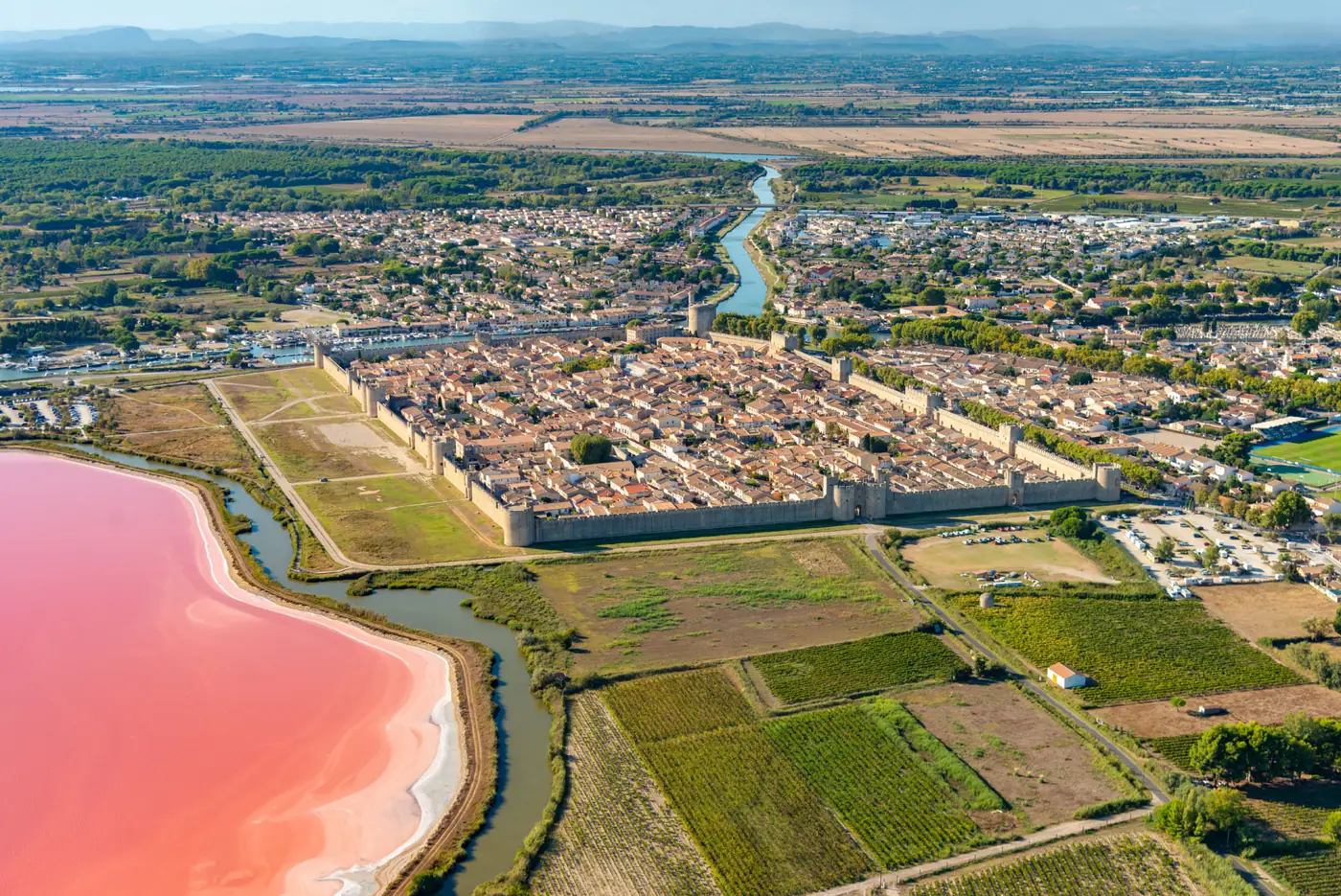 Aigues-Mortes et ses remparts au bord des salins roses, en Camargue